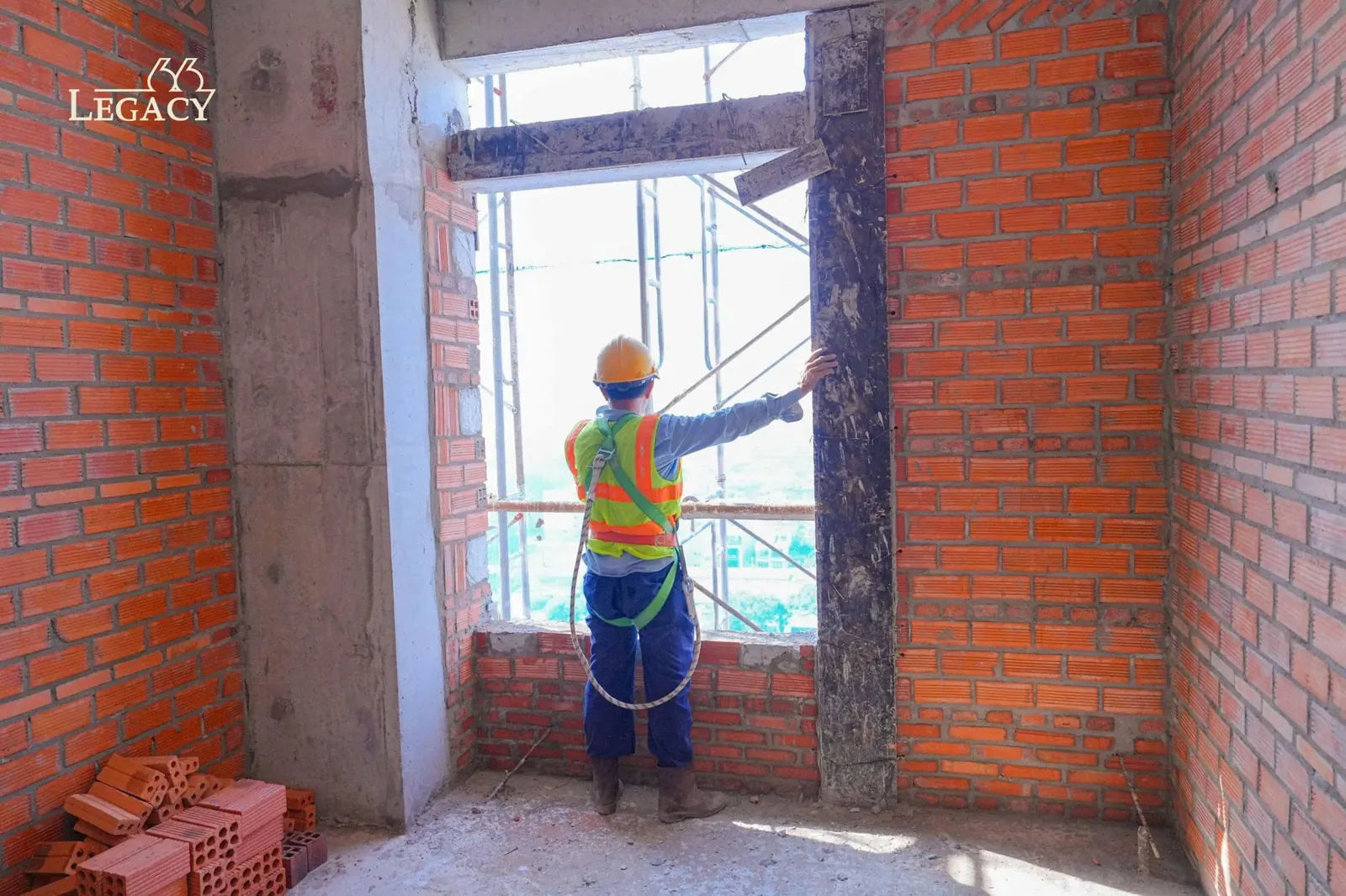 Công nhân xây tường gạch bao che tại tầng cao Legacy 66, tháng 09/2026